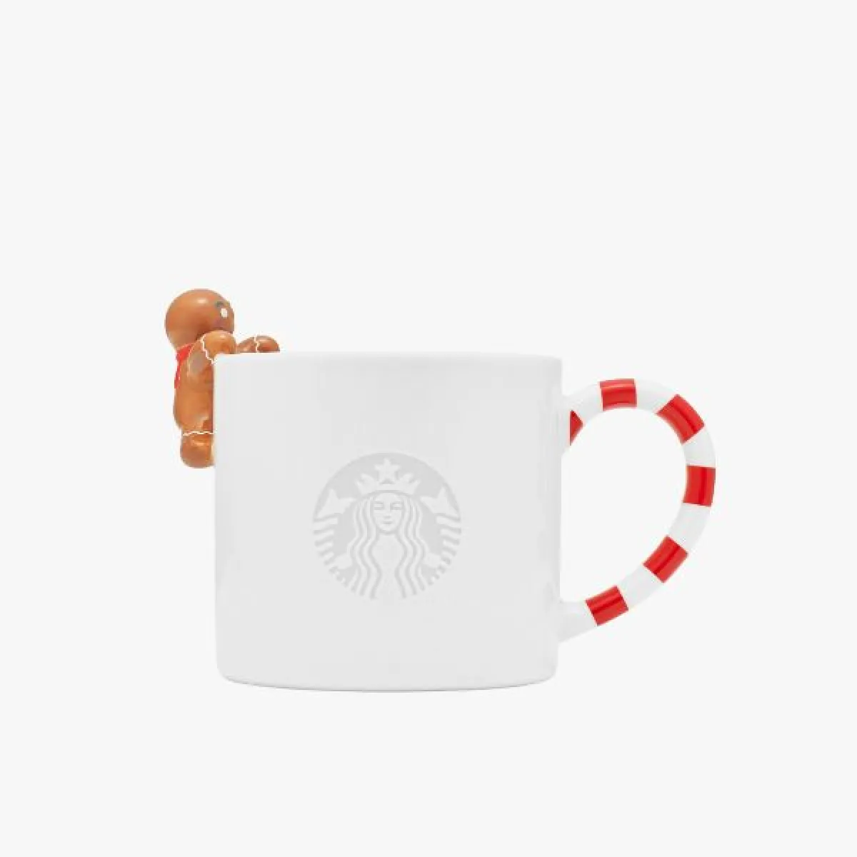 Biely keramický hrnček s uchom v tvare červeno-bielej pruhovanej cukrovej paličky a malou figúrkou perníkového panáčika prichytenou na okraji