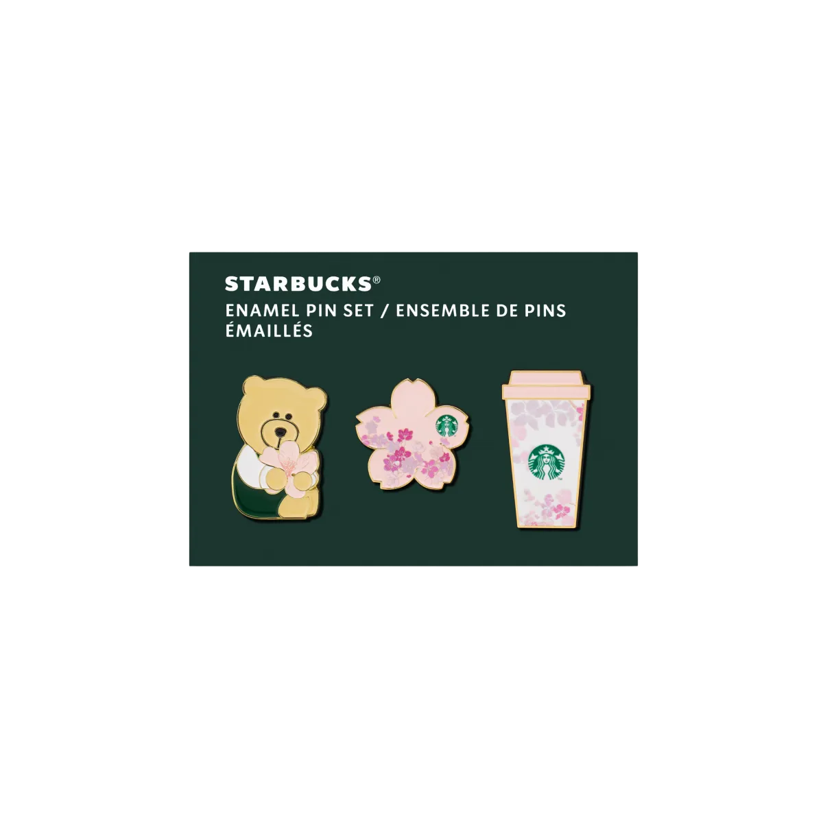 Sada troch smaltovaných odznakov na tmavom podklade. Prvý odznak má tvar medvedíka s kvetinovým motívom, druhý má tvar ružového kvetu sakury a tretí má tvar pohára Starbucks s jemným kvetinovým vzorom. Odznaky sú ladené do jemných ružových, krémových a zelených farieb a majú lesklý povrch.