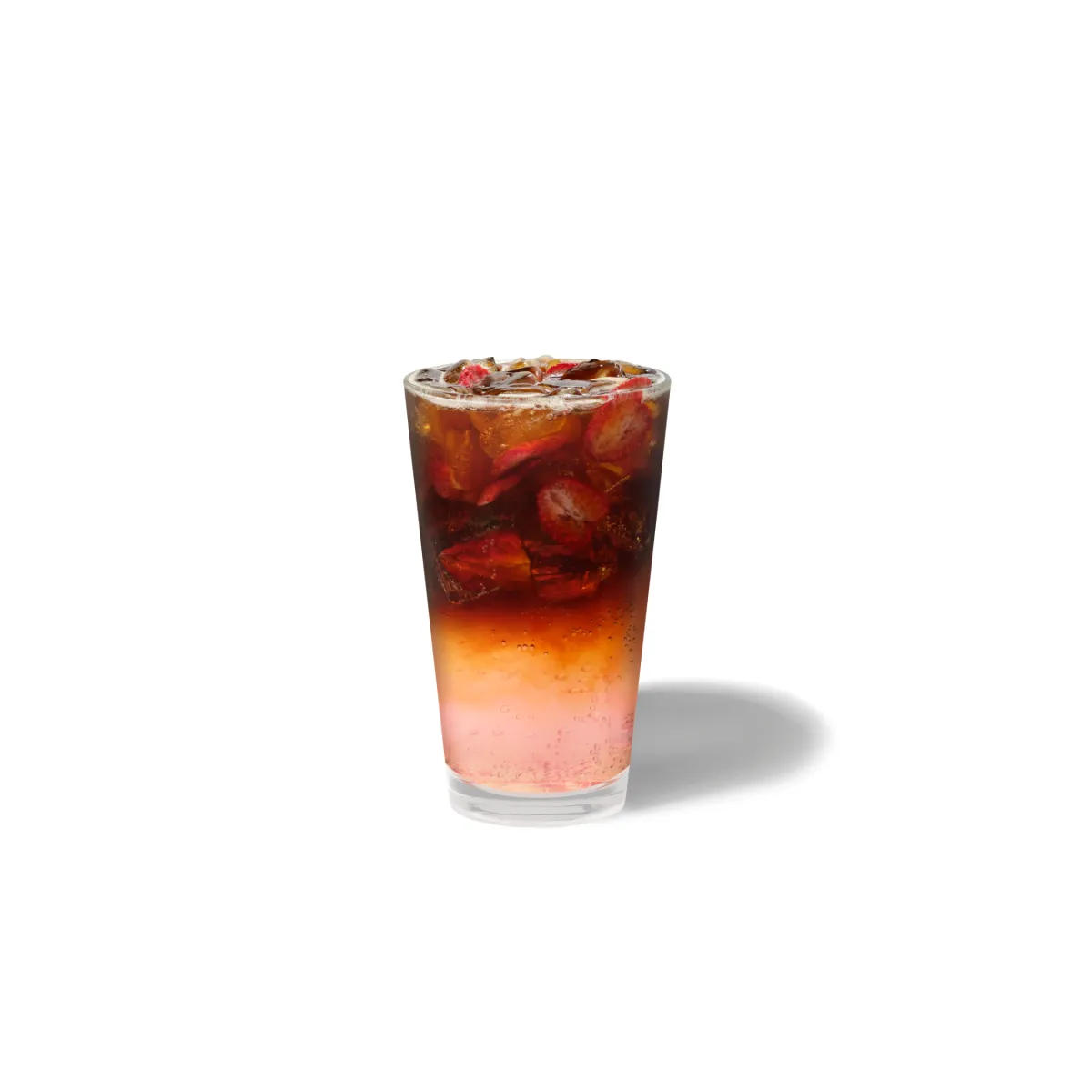 Sparkling Very Berry Espresso Tonic v vysokom pohári, ružový základ prechádza cez jantárovú vrstvu do tmavého espressa, s kúskami sušených jahôd a ľadom navrchu.