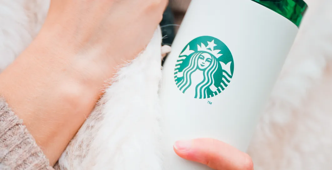 na obrazku človek dží biely tumbler starbucks